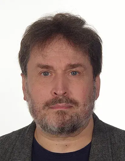 legitymacyjne zdjęcie mężczyzny w średnim wieku, z brodą, krótkimi ciemnymi włosami,  w marynarce, patrzy wprost