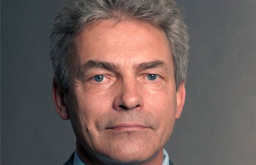 Zdjęcie portretowe: prof. Marek Lefik w ciemnej marynarce, niebieskiej koszuli i krawacie na szarym tle.