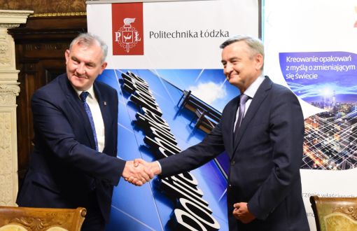 Rektor PŁ prof. Krzysztof Jóźwik i prezes Zarządu DS Smith Polska Krzysztof Sadowski (w garniturach) pozują do zdjęcia. W tle roll upy firm.