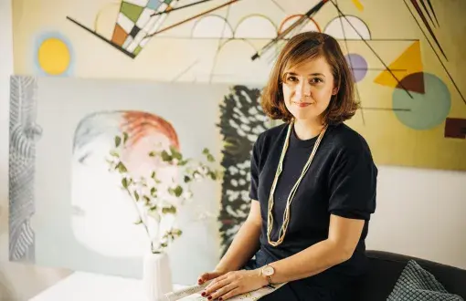 Aleksandra Przedecka na tle swoich prac malarskich.