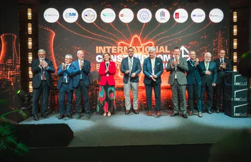 Grupa dziesięciu osób na tle kolorowego banneru konferencji