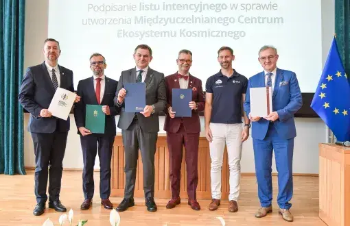 sześciu mężczyzn pozujących w rzędzie na tle banneru  i flagi UE